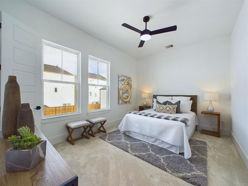 Welcome your guests to a haven of comfort and style in this secondary bedroom. A modern ceiling fan provides a gentle breeze, while wide baseboards add a sprinkle of architectural elegance. Soft carpeting, a spacious closet and large windows are the cherry on top to this bright and welcoming space! *All interior photos are from the model home: 9007 Orange Springs Dr.*