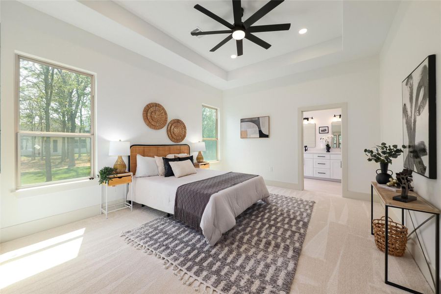 Bedroom featuring light carpet, a raised ceiling, ceiling fan, and recessed lighting