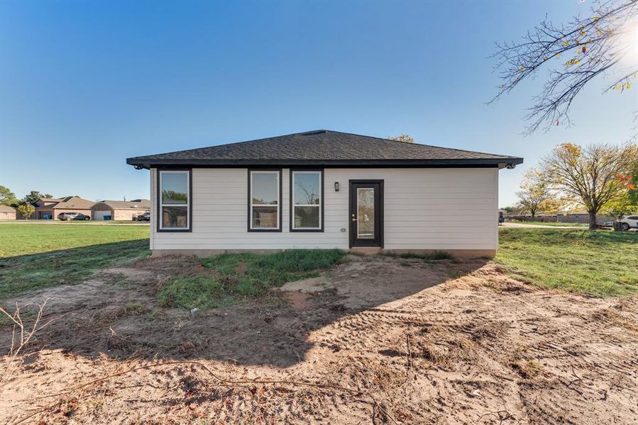 Rear view of property featuring a lawn