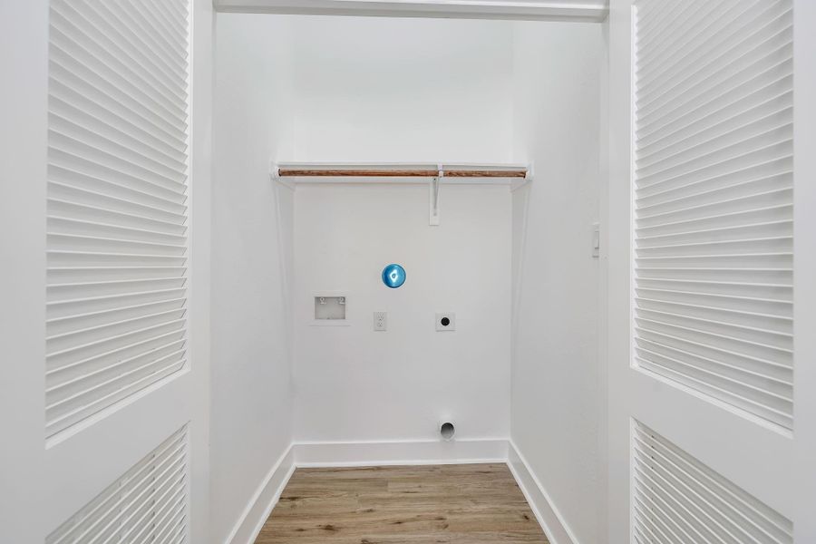 Laundry room conveniently located on the first floor toward the back of the home, with dedicated washer and dryer connections and built-in shelving for storage.