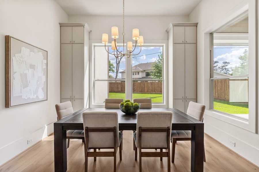 The breakfast space is surrounded by large windows that bring in abundant natural light and offer views of the backyard. Flanked by built-in cabinetry, the area feels both open and intentionally designed.
