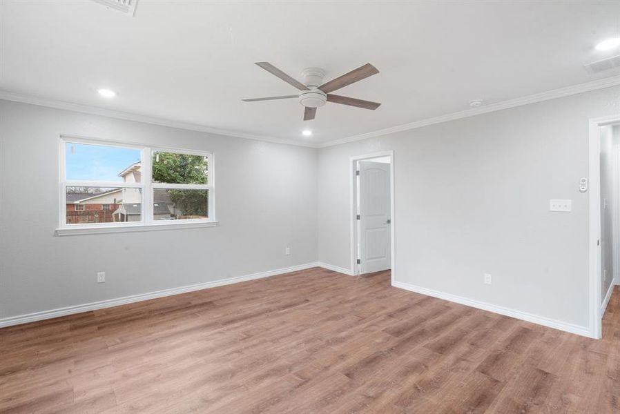 Spare room featuring ceiling fan, crown molding, and light hardwood / wood-style flooring Spare room featuring ceiling fan, crown molding, and light hardwood / wood-style flooring