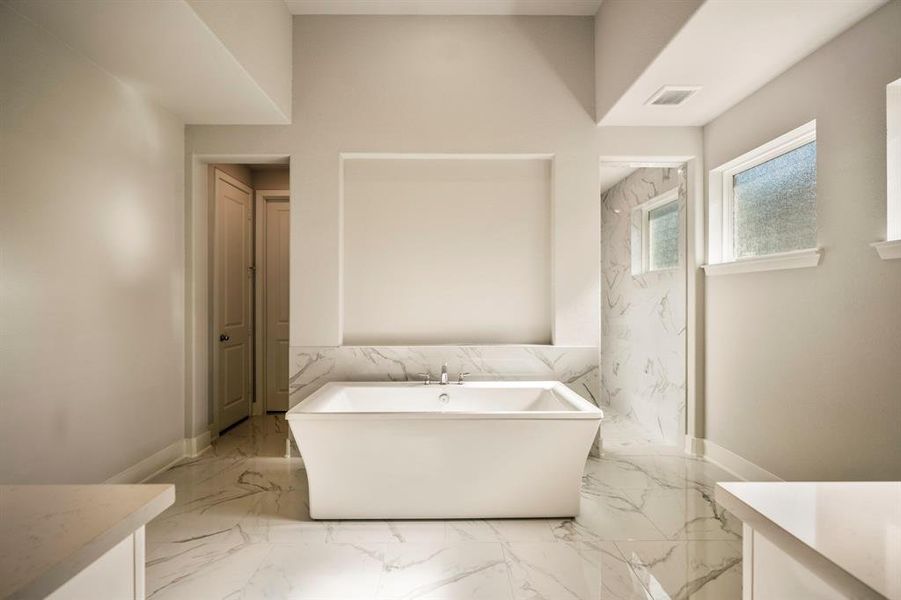 Pure serenity in this spa-like primary bathroom, where luxury meets tranquility. The freestanding tub invites you to unwind, surrounded by elegant finishes and pristine natural light.