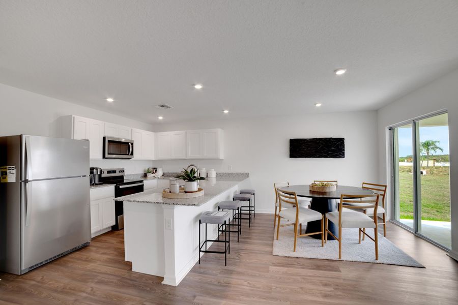 A kitchen with a dining table and a large window.