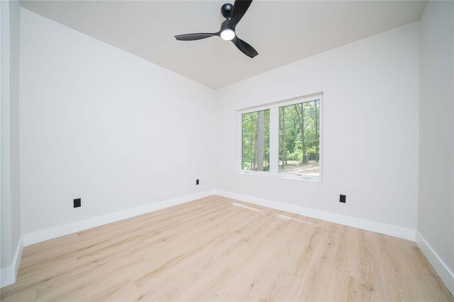 Empty room with wood finished floors and a ceiling fan Empty room with wood finished floors and a ceiling fan