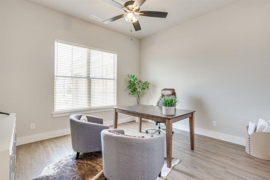 Bedroom 3 featuring wood-finish flooring, a large window with blinds, and a ceiling fan with integrated lighting