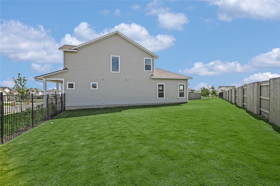 Back of property with a fenced backyard and roof with shingles