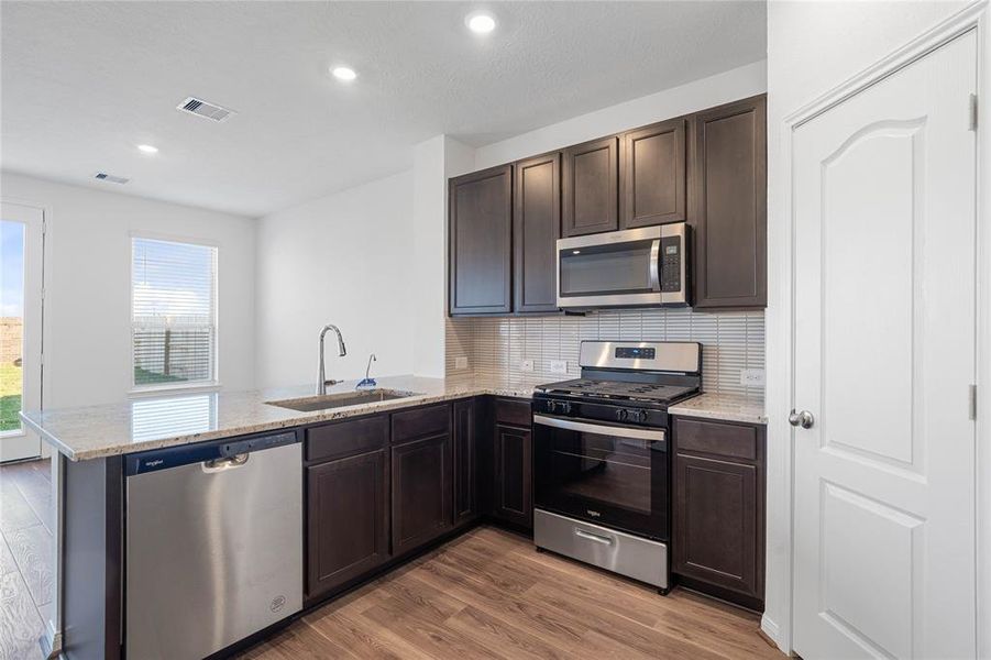 This kitchen is by far any chef’s dream! This spacious kitchen features high ceilings, stained wood cabinets, granite countertops, SS appliances, modern tile backsplash, recessed lighting, space for breakfast bar and a walk-in pantry all overlooking your huge family room.