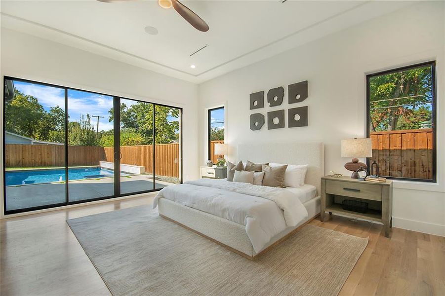 Bedroom with access to outside, multiple windows, light wood finished floors, and ceiling fan
