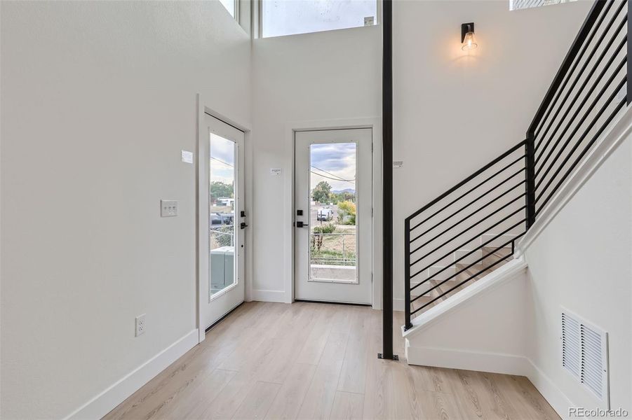 Multilevel atrium entryway flooded with natural light.