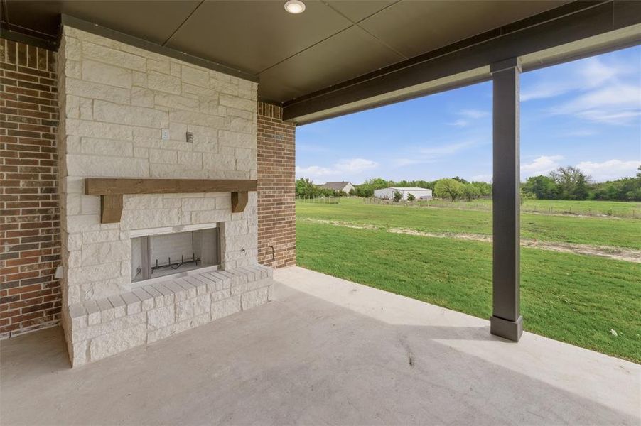 View of patio featuring an outdoor stone fireplace