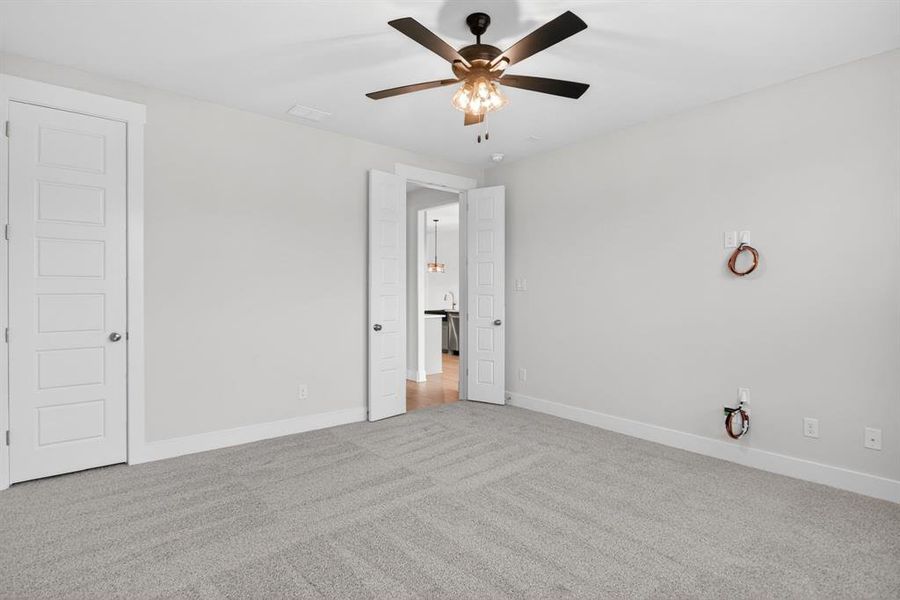 Spacious interior room featuring light gray carpet, neutral wall paint, and white trim Spacious interior room featuring light gray carpet, neutral wall paint, and white trim