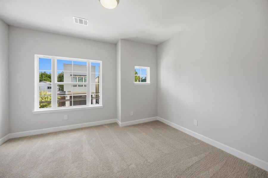 Light and spacious, this larger secondary bedroom at the front of the house shines.
