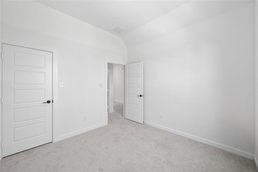 Carpeted room with white walls, a vaulted ceiling, and base molding