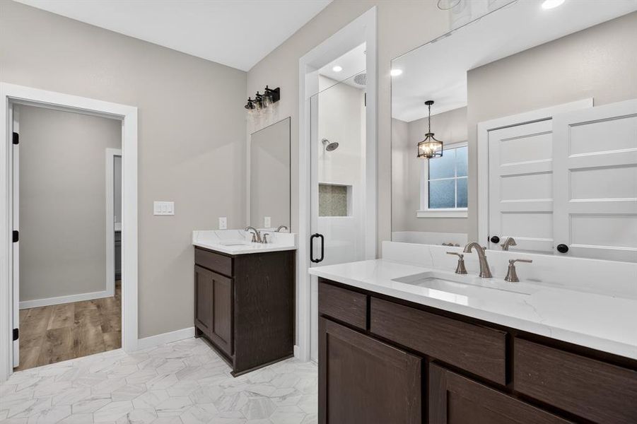 Custom tilework, designer lighting, dual vanities, and walk-in shower plus soaking tub make this space a delight!