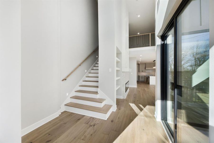 Staircase featuring wood finished floors and a high ceiling Staircase featuring wood finished floors and a high ceiling