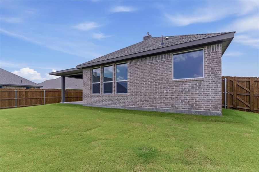 Expansive backyard featuring a manicured lawn, a covered patio, and a privacy fence Expansive backyard featuring a manicured lawn, a covered patio, and a privacy fence