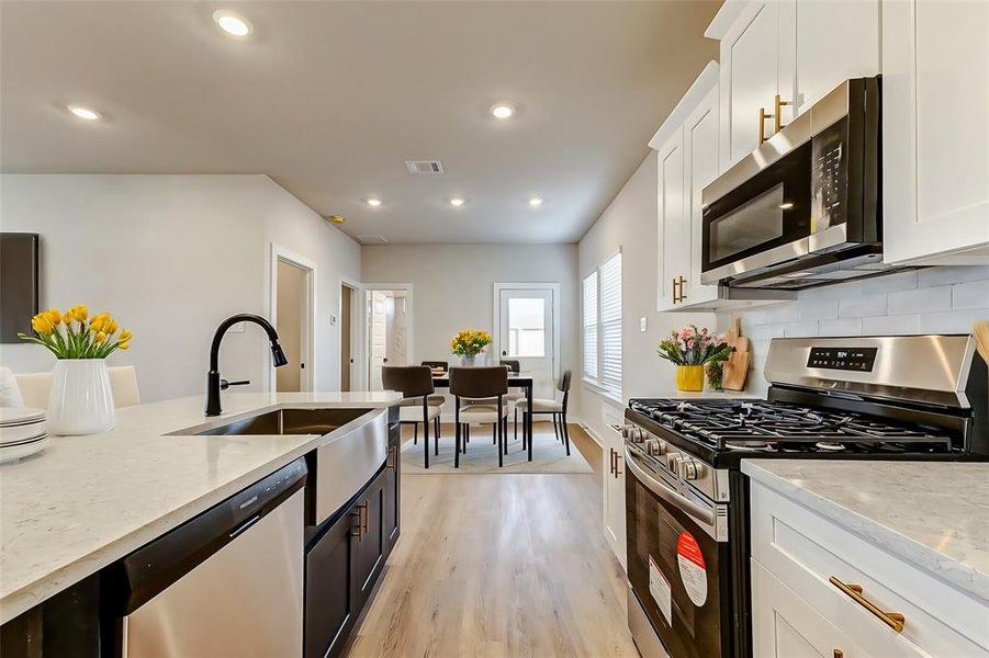 A seamless flow between the kitchen and dining areas offers versatility and space, perfect for hosting family gatherings or intimate dinners.