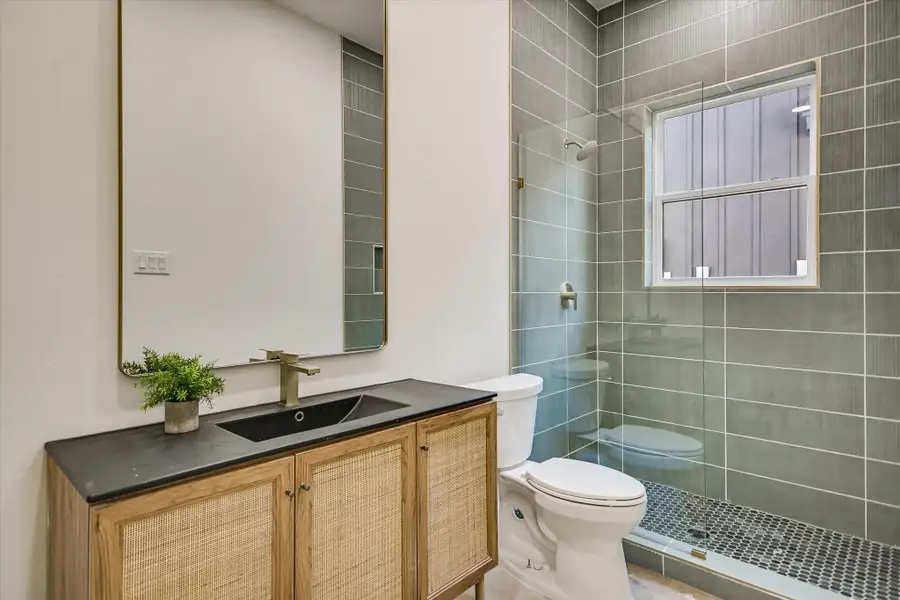 Bathroom with vanity and tiled shower