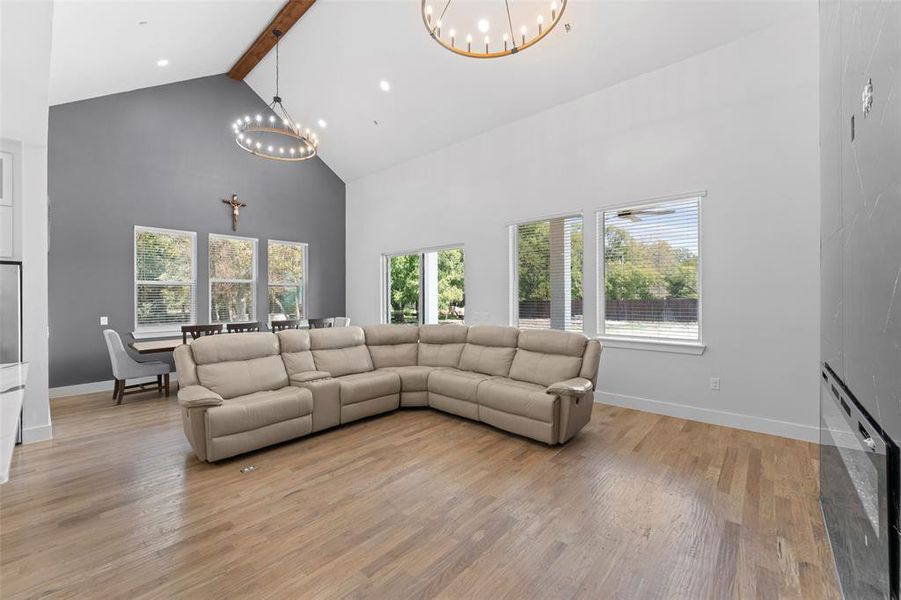 Living area with beamed ceiling, high vaulted ceiling, a chandelier, and light wood finished floors Living area with beamed ceiling, high vaulted ceiling, a chandelier, and light wood finished floors