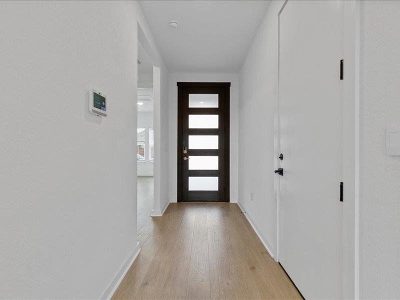 Foyer entrance with light wood-style flooring and baseboards