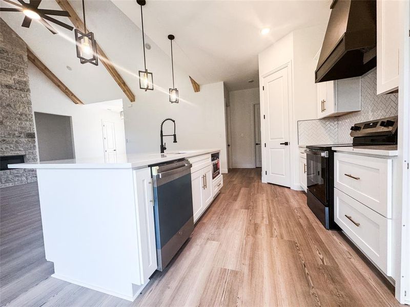 Kitchen with black range with electric stovetop, wall chimney range hood, dishwasher, light wood-type flooring, and decorative backsplash Kitchen with black range with electric stovetop, wall chimney range hood, dishwasher, light wood-type flooring, and decorative backsplash