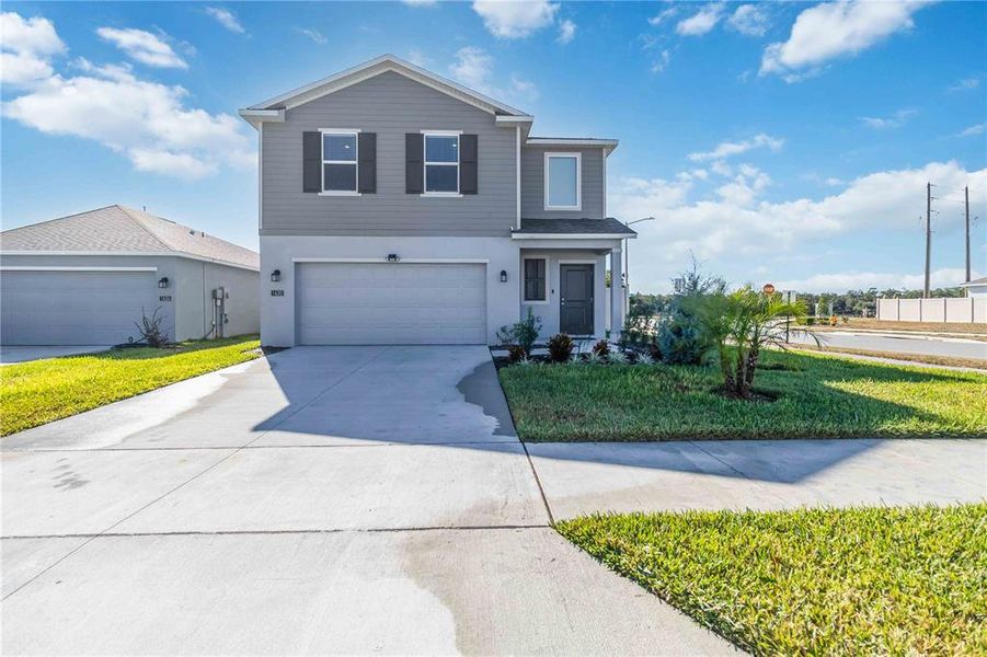 Front exterior of a new home in Peace Creek Reserve: Manor Key Collection, Winter Haven, FL, highlighting curb appeal (Image 2).
