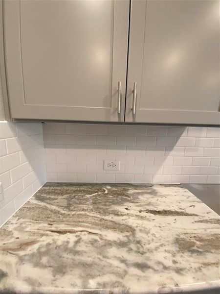 Close up of Fantasy Brown granite counters, white subway tile backsplash, & Grey Shaker cabinets with hardware & soft closing features Close up of Fantasy Brown granite counters, white subway tile backsplash, & Grey Shaker cabinets with hardware & soft closing features