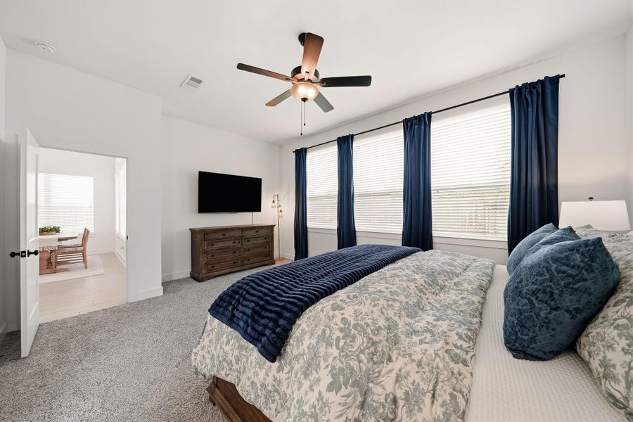 Windows framed by blinds and elegant drapery invite abundant natural light while adding a sophisticated, layered finish to the room.