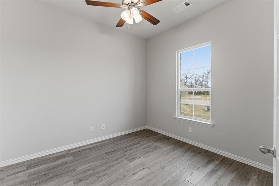 Empty room featuring ceiling fan and light wood-style flooring