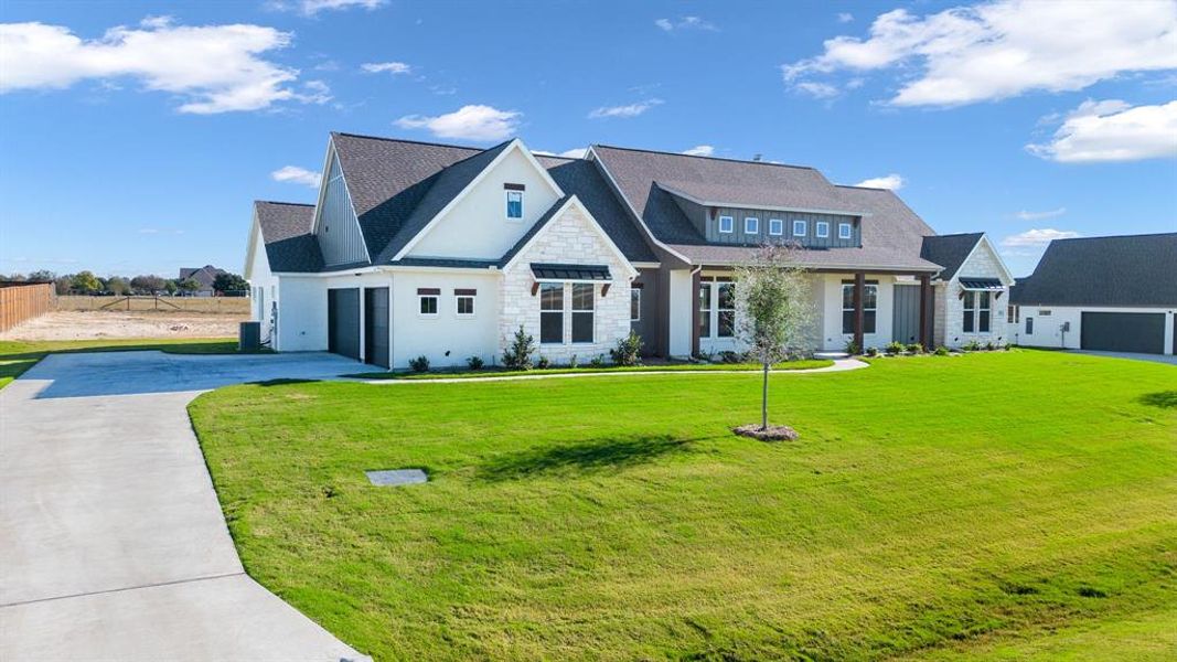 View of front of property featuring a front lawn and a garage