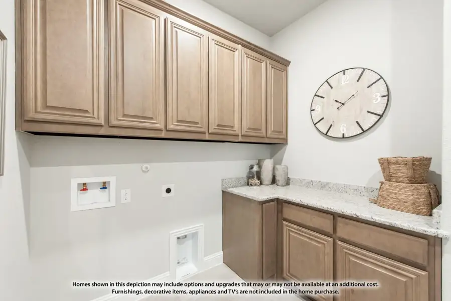 Laundry room with tan wood cabinets, granite countertop, and washer hookups on white walls