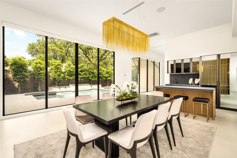 Elegant dining area set along the light-filled corridor, framed by expansive glass and warm architectural detailing.