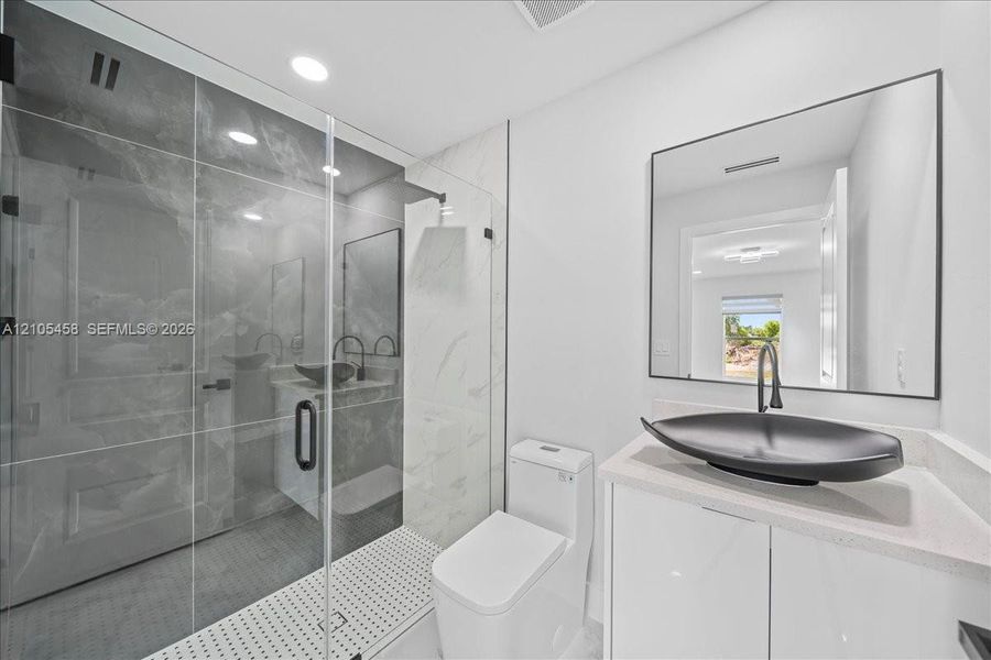 Glass-enclosed shower with large format tile surround Glass-enclosed shower with large format tile surround