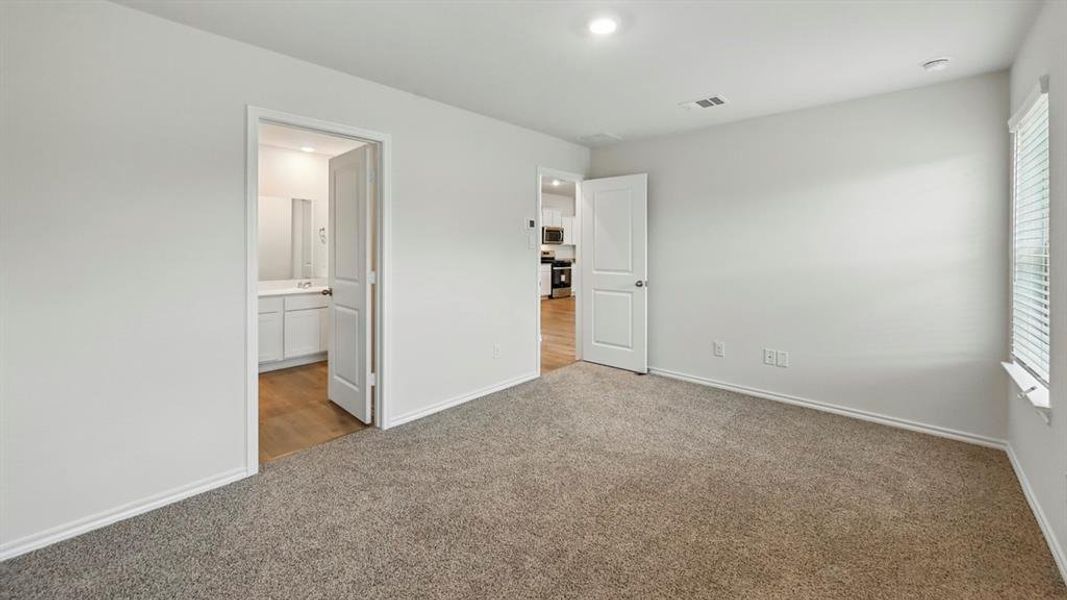 Carpeted room featuring light-colored walls, a window with blinds, and recessed lighting