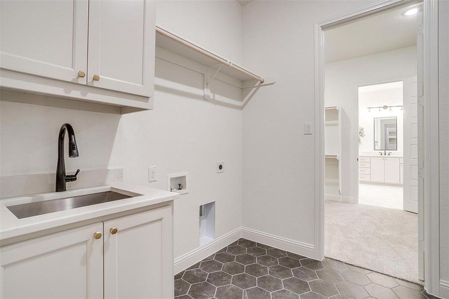 Washroom featuring dark carpet, washer hookup, cabinets, electric dryer hookup, and sink