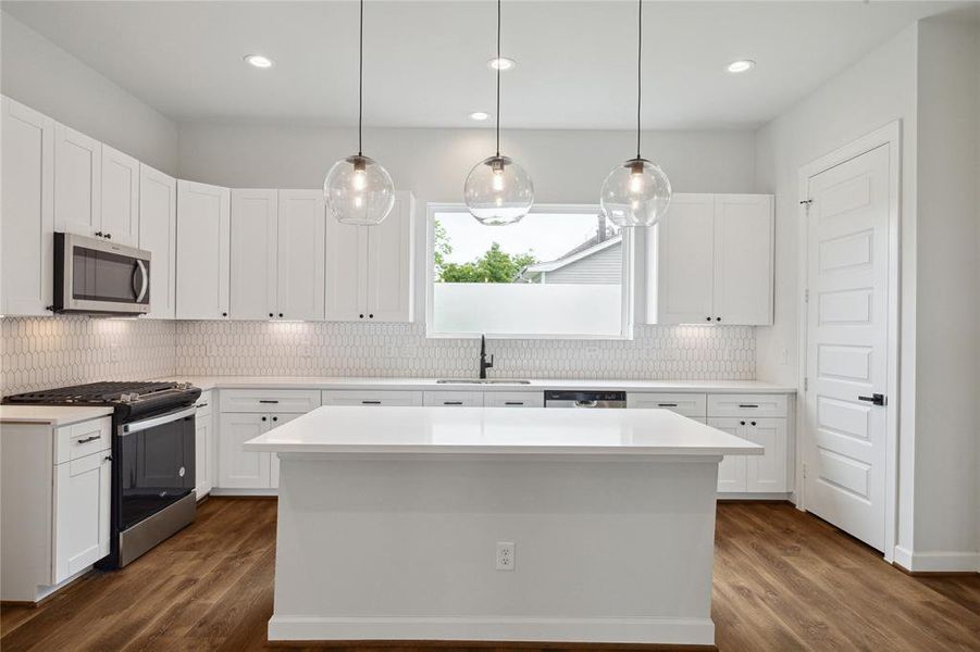 Transform your cooking into a delightful experience with this expansive quartz island, meticulously crafted for function and flair. The island features elegant pendant lighting overhead and complementing recessed lighting, offering ample light.