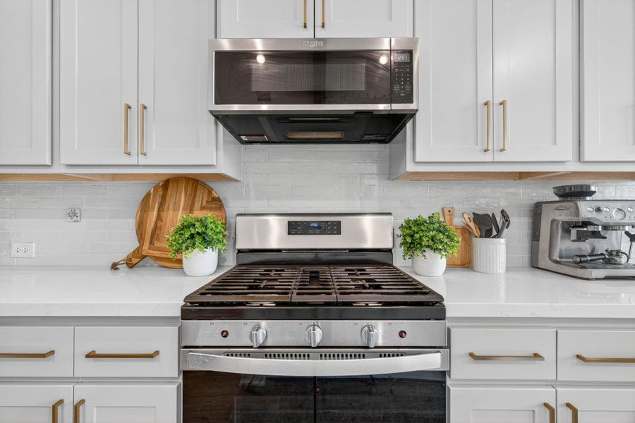 This gourmet kitchen has white backsplash, a 5-burner gas range with a stainless steel microwave. 31418 Golden Cliffs Ln., Fulshear, TX 77441 This gourmet kitchen has white backsplash, a 5-burner gas range with a stainless steel microwave. 31418 Golden Cliffs Ln., Fulshear, TX 77441