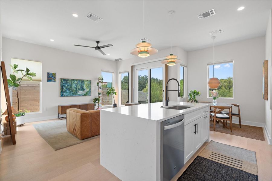 A contemporary open-concept layout features a well-appointed kitchen island, seamlessly connecting to the living area with tall windows inviting natural light. A contemporary open-concept layout features a well-appointed kitchen island, seamlessly connecting to the living area with tall windows inviting natural light.