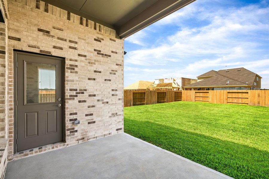 Experience outdoor living at its finest on this expansive covered patio, thoughtfully designed for BBQs and delightful outdoor dining. Sample photo of completed home with similar floor plan. As-built interior colors and selections may vary.