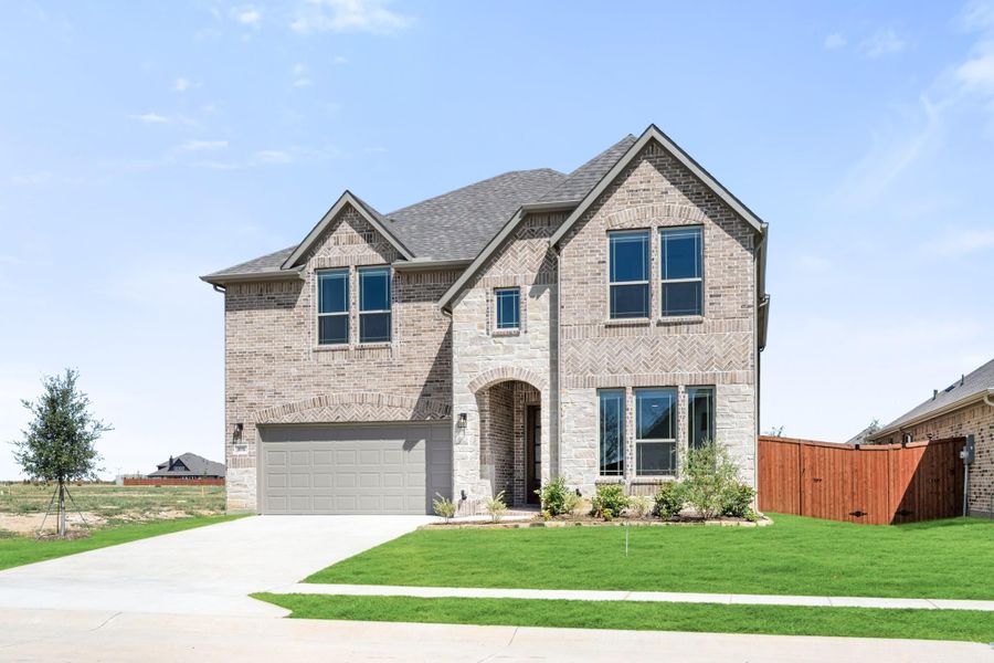 Two-story brick home with arched entry, two-car garage, and manicured front lawn Two-story brick home with arched entry, two-car garage, and manicured front lawn