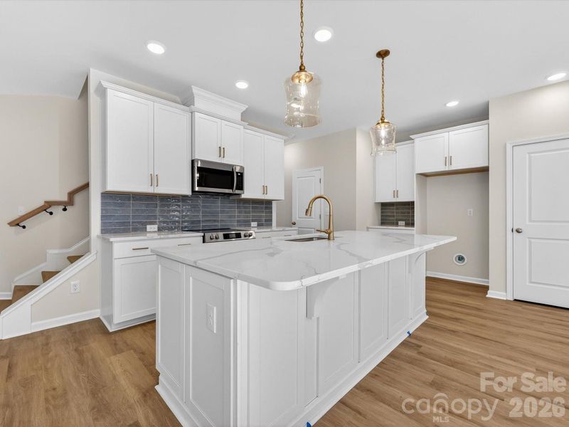 42' cabinets with soft close cabinets & drawers, quartz countertops, pantry with solid shelves. Cooking is vented to the outside