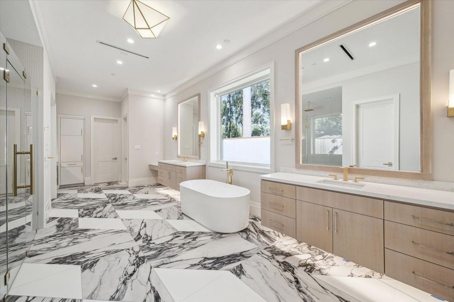 The primary bath showcases gorgeous porclain and glass tile flooring and includes two separate water closets.