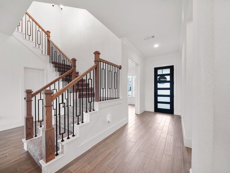 The sweeping staircase is a statement feature, adding architectural elegance while connecting the main living spaces to the upstairs retreat.