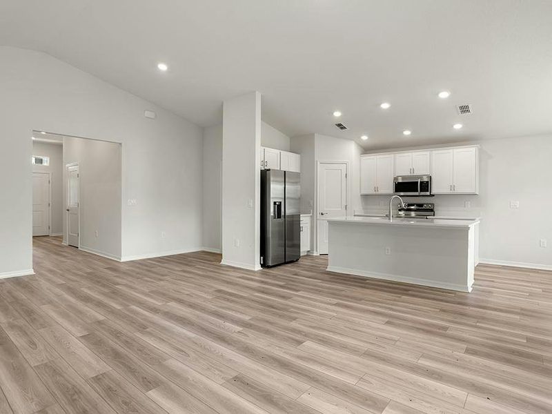 Enjoy a sunny, open living area with volume ceilings and LVP flooring.