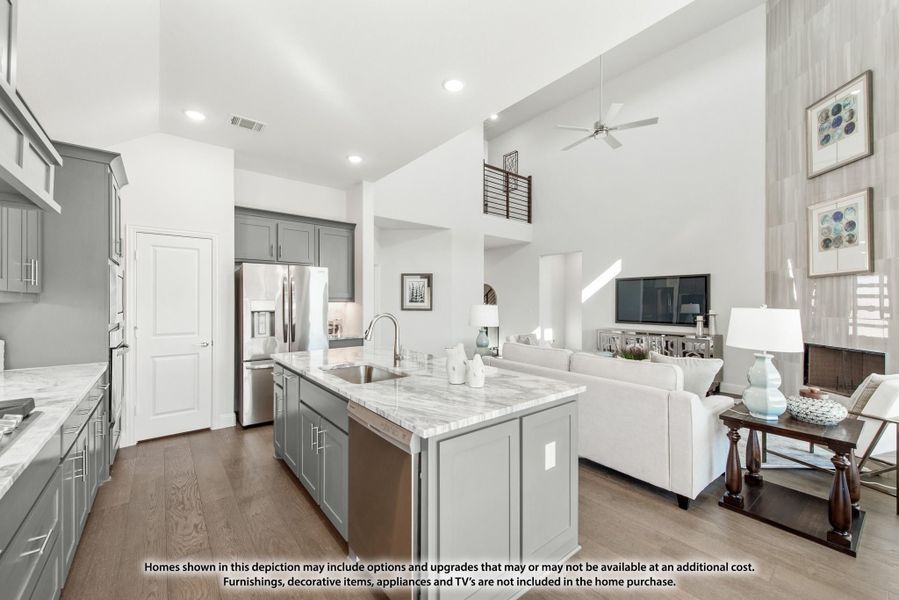 Open-concept kitchen with gray cabinets, marble island, and living room with high ceilings and hardwood floors Open-concept kitchen with gray cabinets, marble island, and living room with high ceilings and hardwood floors