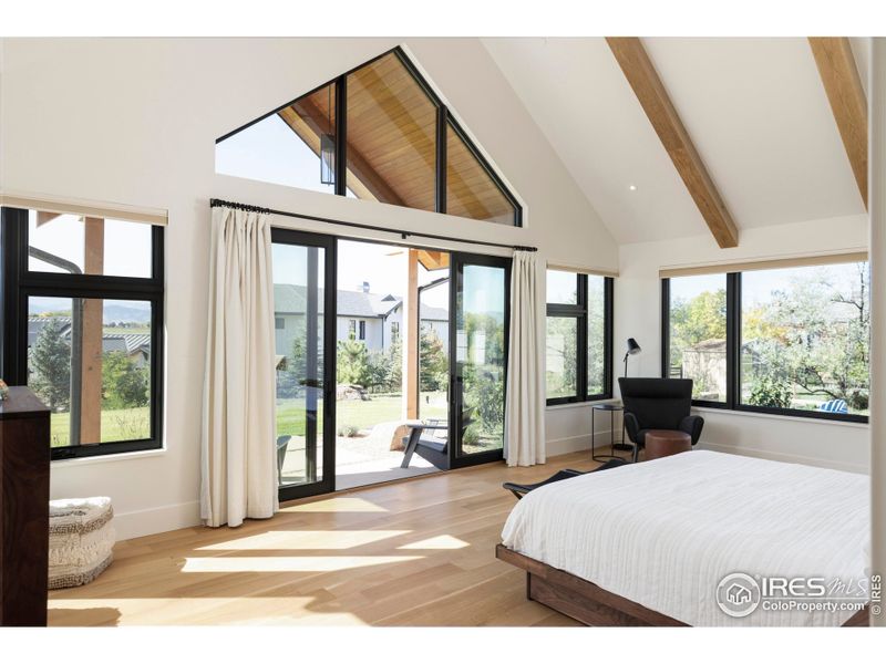 Striking primary suite with vaulted ceilings, exposed beams and mountain views. Striking primary suite with vaulted ceilings, exposed beams and mountain views.