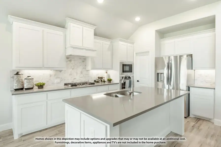 Kitchen with white cabinets, gray quartz island, marble backsplash, and stainless steel appliances Kitchen with white cabinets, gray quartz island, marble backsplash, and stainless steel appliances