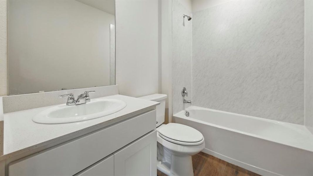 Full bathroom with vanity, shower / washtub combination, and dark wood-style flooring
