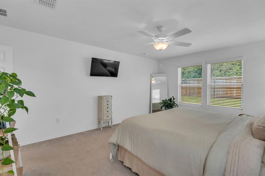 Bedroom with light colored carpet and a ceiling fan
